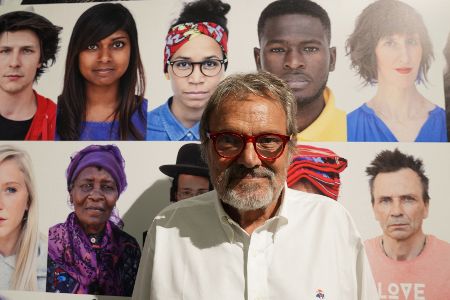 Oliviero Toscani vor einer Bildercollage