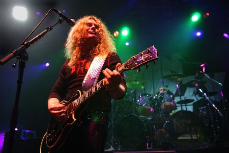 John Sykes mit Gitarre auf einer Bühne