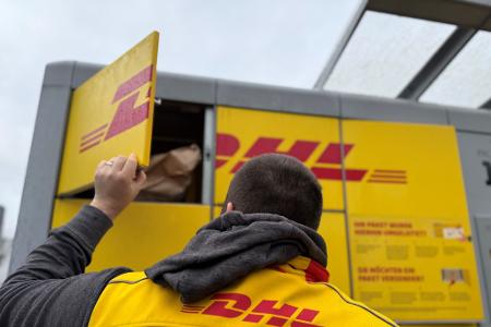 Ein typischer DHL-Paketautomat, der gerade von einem Paketboten befüllt wird. (Archivbild)