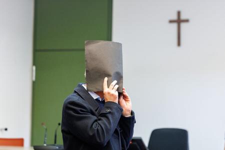 Der Angeklagte versteckte zu Prozessbeginn sein Gesicht. Er bestreitet die Vorwürfe. 