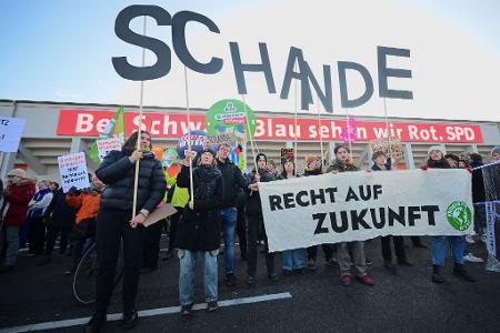 Zum Parteitag demonstrieren mehrere Menschen vor dem Gebäude. 