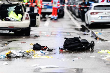 Kleidung und ein Kinderwagen liegen nach dem Anschlag auf der Straße.