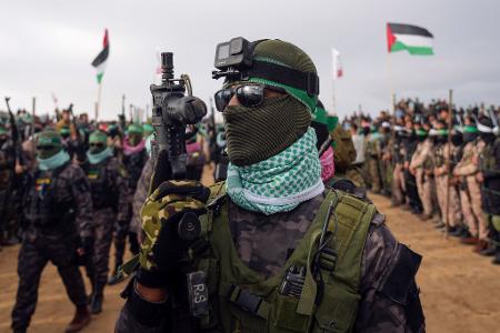 Vermummte Kämpfer der Hamas bei der Übergabe von vier toten Geiseln