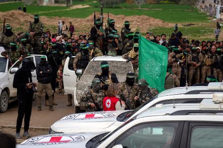 Eine Vertreterin des Roten Kreuzes spricht mit Hamas-Mitgliedern. 