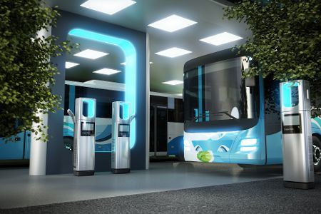 Elektrobus vor einer futuristischen Ladesäule