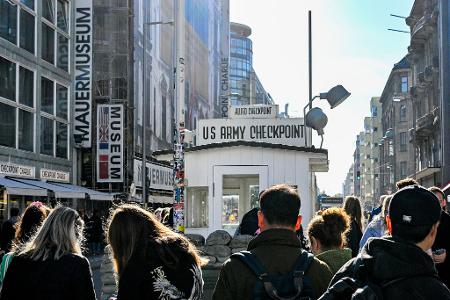 Touristen sind am Kontrollhaus am Checkpoint Charlie vor dem 