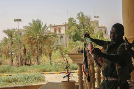 Ein sudanesischer Soldat mit der Nationalfahne nach der Rückeroberung des Präsidentenpalasts in Khartum
