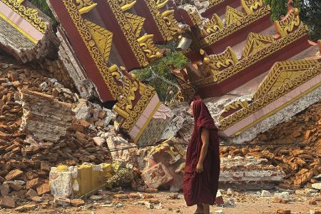 Ein buddhistischer Mönch geht in der Nähe einer eingestürzten Pagode nach einem Erdbeben in Mandalay. Ein buddhistischer Mönch geht in der Nähe einer eingestürzten Pagode nach einem Erdbeben in Mandalay.