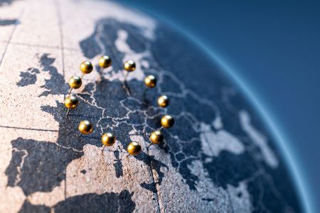 Europa auf einer Weltkugel aus Kork mit goldfarbenen Nadeln im Kreis wie europäische Flagge
