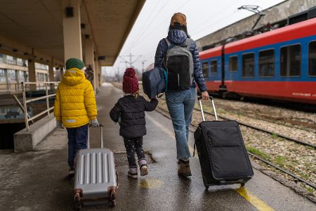 Frau mit zwei kleinen Kindern am Bahngleis