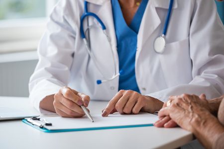 Arzt erklärt Testergebnisse auf einem Klemmbrett