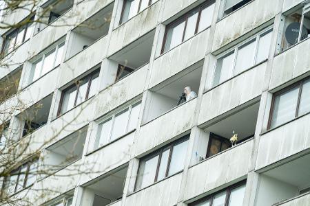 Ermittler untersuchen einen Balkon des Hochhauses. 