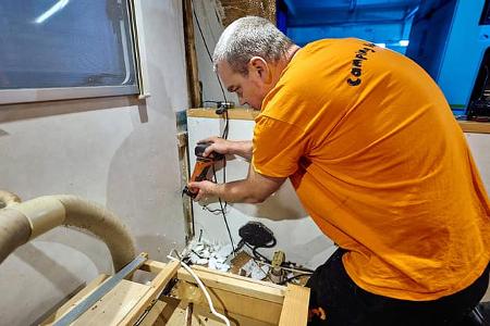 Mann, Multitool, Schlauch, Holz, Freilegen