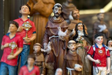 Figuren des alten und des neuen Heiligen stehen in den Souvenirhops nebeneinander. (Foto: Archiv)