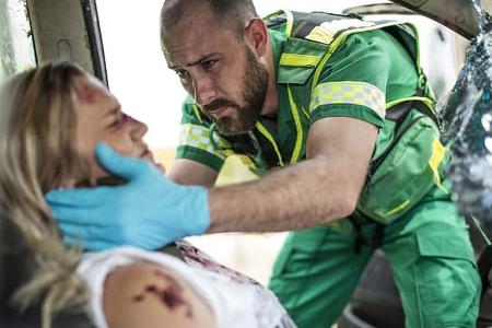 Paramedic helping car crash victim after accident