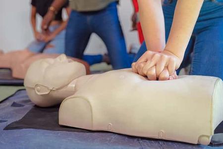 Hands Of A trainee doing chest compression during defibrillator CPR Training.