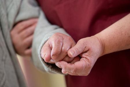 Eine Pflegekraft betreut in einem Seniorenhaus einen Bewohner. Eine Pflegekraft betreut in einem Seniorenhaus einen Bewohner.