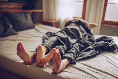 Zwei Menschen liegen ineinander verwickelt im Bett