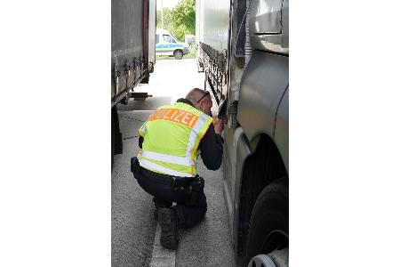 Polizist kontrolliert einen Lkw Polizist kontrolliert einen Lkw