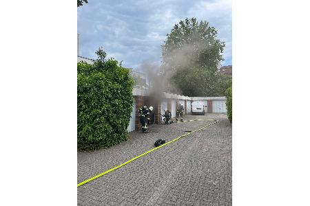 Einsätzkräfte dringen in die verrauchte Garage vor Einsätzkräfte dringen in die verrauchte Garage vor
