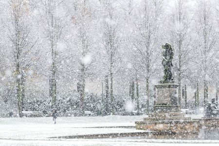 Schneebedeckte Landschaft mit Statue im Bürgerpark in Bremen