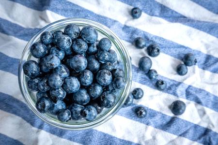 Beeren statt Chips oder Nüsschen: Heidelbeeren, auch Blaubeeren genannt, liegen auf einem Esstisch und werden gern gesnackt. Beeren statt Chips oder Nüsschen: Heidelbeeren, auch Blaubeeren genannt, liegen auf einem Esstisch und werden gern gesnackt.