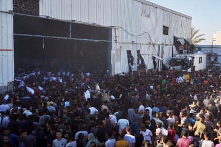 Palästinenser tragen Säcke mit Mehl, nachdem sie ein Lagerhaus des Welternährungsprogramms der Vereinten Nationen in Zawaida im zentralen Gazastreifen gestürmt haben.