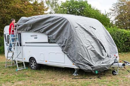 Die Schutzhülle wird von vorne nach hinten über den Caravan gezogen.