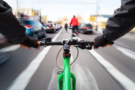 Radfahrer fährt auf dem Radweg vorbei am Stau-First-Person-Ansicht von Radfahrrad/Bewegungsunschärfe