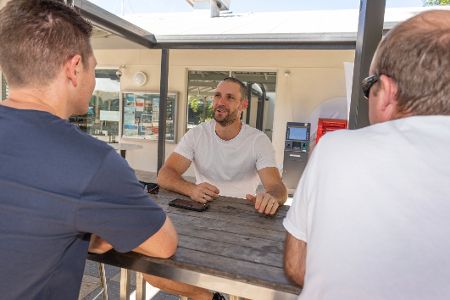 Männer sitzen draußen bei Unterhaltung