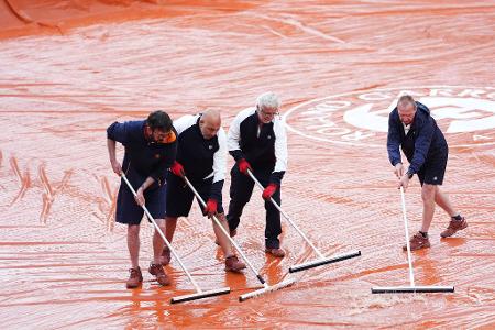 Ganz nasses Tennis: Bei den French Open in Paris wird vor einem Spiel der Junioren im Stadion Roland Garros Regenwasser vom Platz gewischt.