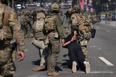 Die militärisch anmutenden Sicherheitskräfte des Bundes nehmen Demonstranten fest.