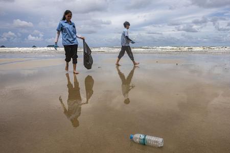 Freiwillige Helfer sammeln im Rahmen einer inselübergreifenden Initiative zum Weltozeantag Müll an einem Strand von Koh Chang in Thailand.