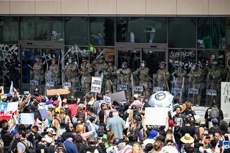 Einheiten der Nationalgarde stehen protestierenden Menschen am Federal Building auf der Los Angeles Street in Downtown LA gegenüber.