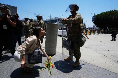 Eine Frau legt Blumen vor der Nationalgarde nieder. 