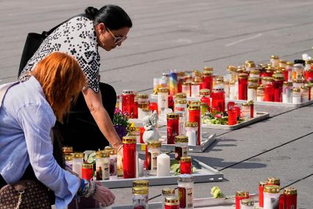 Menschen zünden auf dem Hauptplatz in Graz Kerzen zum Gedenken an die Opfer des Amoklaufs an einer Schule an. 