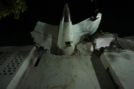 Das Heck eines Flugzeugs ragt aus in einem Gebäude an der Absturzstelle in der nordwestindischen Stadt Ahmedabad im Bundesstaat Gujarat.