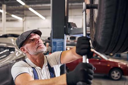 Bearded,Man,In,Gloves,Tightening,Bolts,On,Wheel,With,Torque