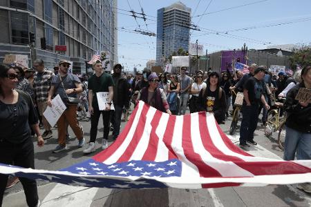 Demonstranten in San Francisco marschierten mit einer großen US-Flagge.