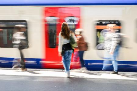 Fahrgäste stehen am Hauptbahnhof Hannover vor einer einfahrenden S-Bahn.