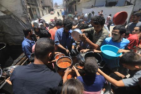 Hunger in Gaza: Palästinenser warten auf die Ausgabe von Essen, das von Wohltätigkeitsorganisationen in Gaza-Stadt verteilt wird.