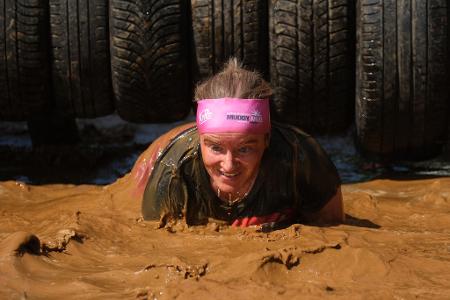 Durchs Schlammbecken steigt diese Frau beim Muddy Angel Run auf der Galopprennbahn Scheibenholz.