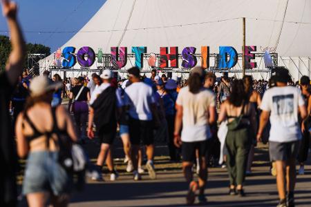 Menschen gehen über das Gelände des Southside Festivals.