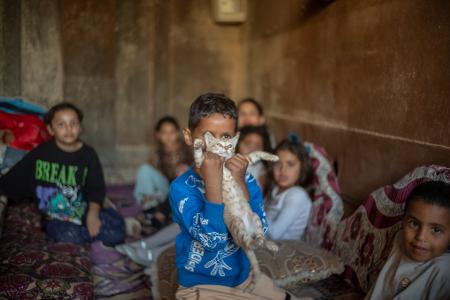 Kinder versammeln sich in dem behelfsmäßigen Bunker, der aus einem in Erde eingegrabenen Kieslaster gebaut wurde, um sie vor ankommenden iranischen Raketen in dem nicht anerkannten Dorf Al-Furaa zu schützen.