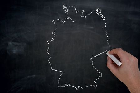 Hand mit Kreide zeichnet Deutschlandkarte