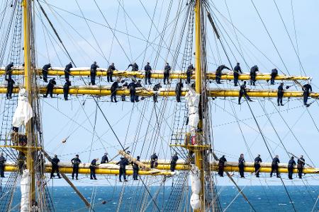 Marinesoldaten stehen bei der Ausfahrt aus dem Hafen Warnemünde an den Rahen auf dem Segelschulschiff Gorch Fock. 