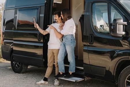 adult couple making a video call with their iPad in a camper van adult couple making a video call with their iPad in a camper van