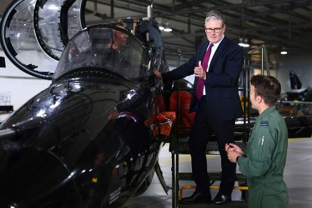 Der britische Premierminister Keir Starmer (auf der Leiter) informiert sich über einen Hawk T2, den ersten Trainer für schnelle Jets der Royal Air Force (RAF), während eines Besuchs der RAF Valley in Anglesey, Nordwales.