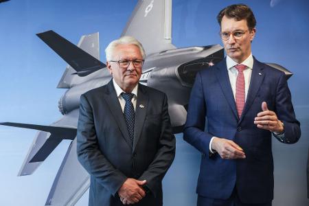 Papperger und Wüst vor einem Bild des F-35-Flugzeugs. Ende nächsten Jahres soll das erste Rumpfmittelteil dieses Tarnkappenbombers in Weeze fertig sein.