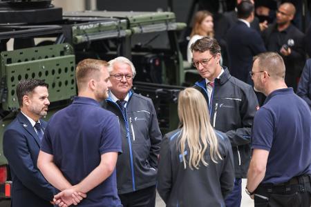 Rheinmetall-Chef Armin Papperger (Dritter von links) und NRW-Ministerpräsident Hendrik Wüst (zweiter von rechts) bei einem Rundgang durch die F-35-Produktionsanlage.